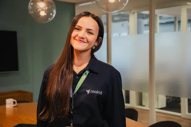 Colaboradora da Mainô com o uniforme da marca no escritório
