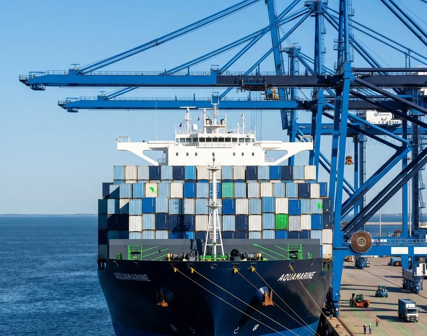 Navio porta-contêineres atracado sob os guindastes de um porto